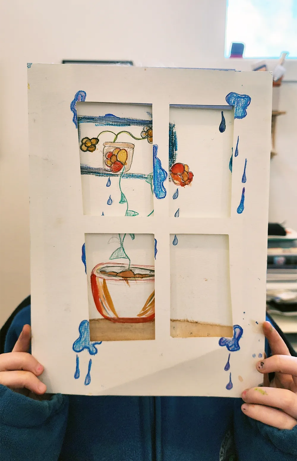 A student holding up a pop-up illustration of perfume bottles she designed
