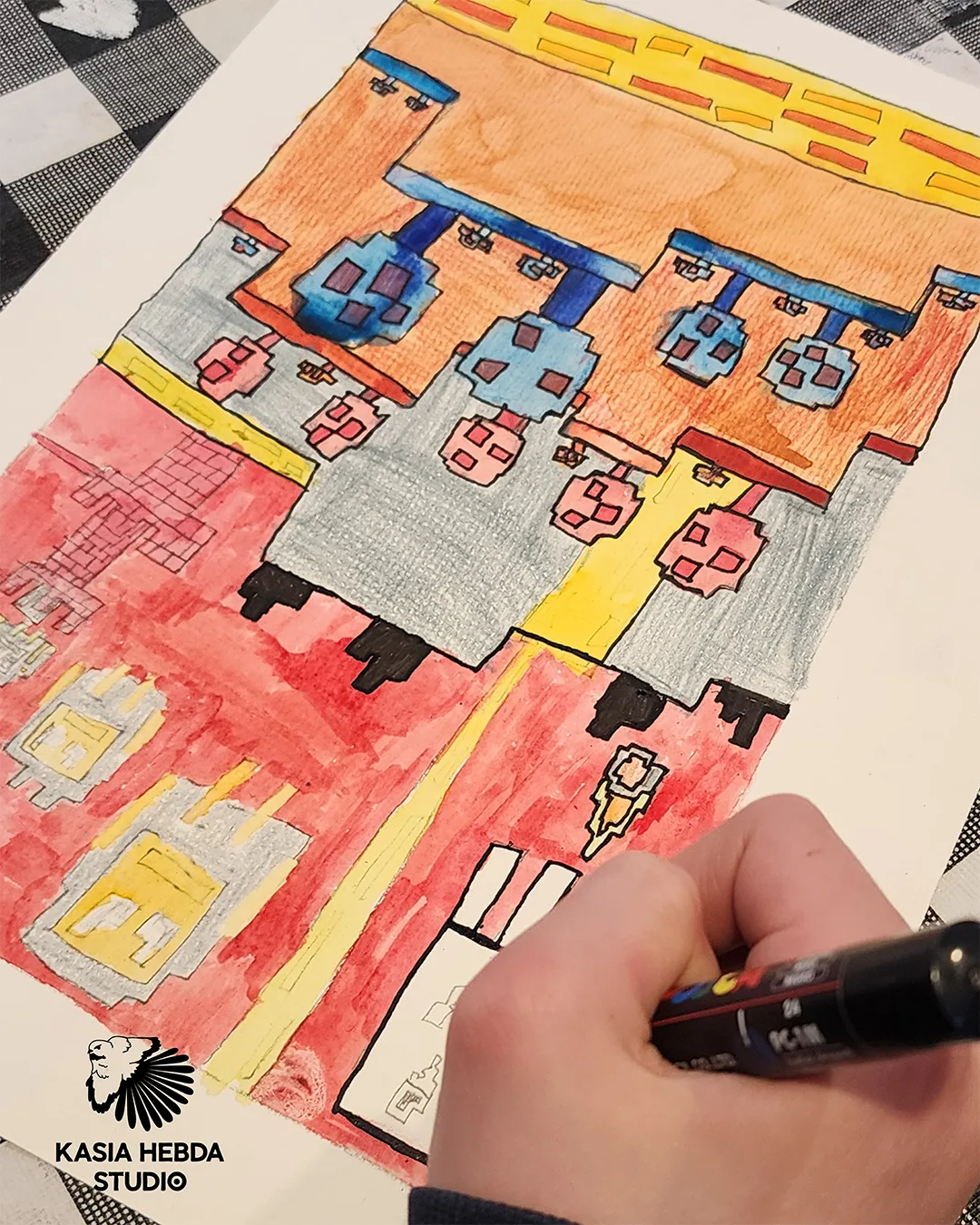 A student drawing a detailed city street scene in marker and pencil